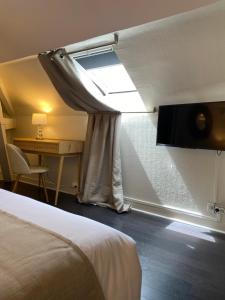 尚蒂伊林荫大道酒店的客房设有床、窗户和书桌。