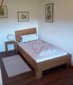 阿尔高内的伊门施塔特Huis am Berg的白色墙壁的客房内的一张木床