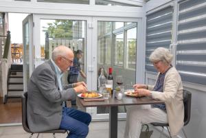 加勒穆恩加勒穆恩住宿加早餐酒店的坐在餐桌旁吃食物的年长男女
