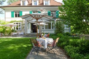 苏黎世Signau House & Garden Boutique Hotel Zürich的屋前带雨伞的桌子