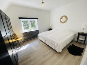 德哈恩Lovely, renovated appartment, near the beach.的白色的卧室设有床和窗户