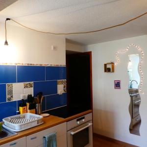 拉卡努尔格Gîte insolite dans la Microbrasserie & Auberge Ortan的厨房的墙壁上铺有蓝色瓷砖。