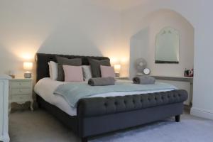 BozeatBozeat Retreat & York Cottage Spa的卧室配有一张带粉红色枕头的大床