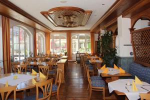 莱奇根Landgasthof Hotel Lamm的餐厅设有木桌、椅子和窗户。