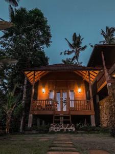 新加拉惹Uma d'Nyuh Homestay的夜晚在树林里的一个小屋