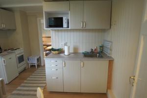 AveroySolstrand的厨房配有白色橱柜和水槽
