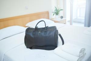 塞萨洛尼基特尔里尼酒店的睡床上的黑包