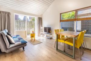 栋堡Vakantiehuis Domburg Cabanas DO37的客厅配有木桌和黄色椅子