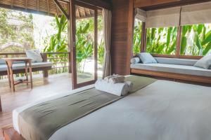 吉利特拉旺安番石榴园酒店的一间带一张大床的卧室,位于带窗户的房间内