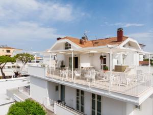 里乔内BeYou Hotel Villa Rosa的白色的房子,设有带白色椅子的阳台