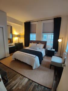 巴尔的摩Inner Harbor's Best Furnished Luxury Apartments apts的一间卧室设有一张大床和两个窗户。