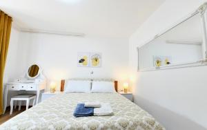 拉科维察Apartmani Brium的白色卧室配有床和书桌