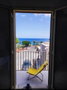 伊索拉戴里费米尼Casa Levante的阳台的黄色椅子,享有海景