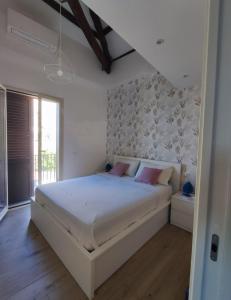 伊索拉戴里费米尼Casa Levante的卧室配有带粉红色枕头的大型白色床