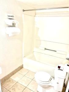 哈钦森Vento Hotel的白色的浴室设有卫生间和浴缸。