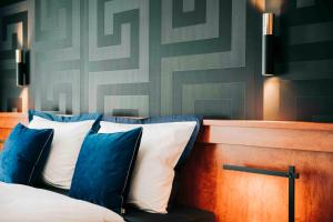 维尔茨堡DAS v EVERT Hotel - am Congress Centrum Würzburg的一间卧室配有一张带蓝色和白色枕头的床