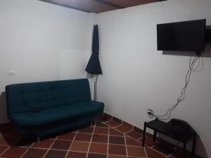 马里尼亚Casa de descanso en marinilla的客厅配有绿色沙发和电视