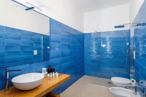 普罗奇达La Casa sul Faro的蓝色的浴室设有2个水槽和淋浴。