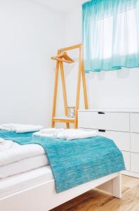 下厄尔什365Balaton Apartmanok的白色客房,配有一张带蓝色毯子的床