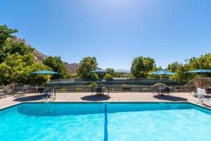 拉莫纳圣地亚哥乡村庄园酒店的一个带桌椅和遮阳伞的游泳池