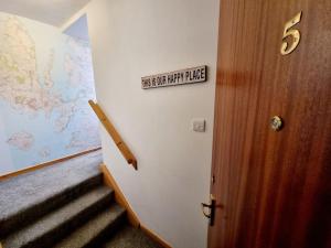 因弗内斯One Bed Holiday Home in the Heart of Inverness的墙上有标志的房间的楼梯