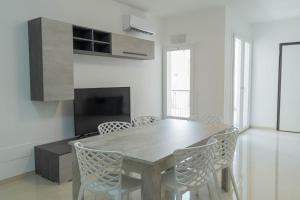 波扎洛Raganzino Apartment Pozzallo - new building的一间带木桌和椅子的用餐室