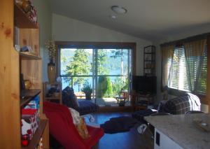 伦弗鲁港狂野海岸度假屋的客厅设有大窗户和红色沙发