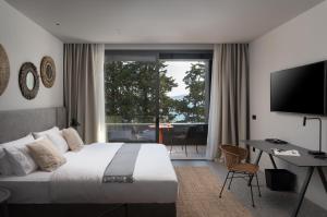 扎达尔La Vista Suites的一间卧室配有一张床、一张书桌和一台电视