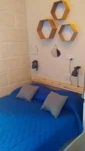 维多利亚Triesti Home的一间卧室配有蓝色的床和两个枕头