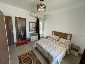 阿莱曼Amwaj Seaside Retreat- Luxury 2BR Chalet in Amwaj Sidi Abdelrahman的一间卧室配有床、水槽和镜子