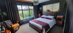 塔卡卡怀塔普泉住宿加早餐旅馆的卧室配有床、椅子和窗户。