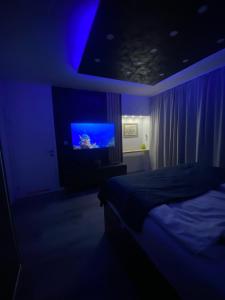 萨拉热窝Festival Centar Sarajevo的一间黑暗的房间,配有床和电视