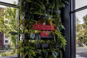 奥斯陆Radisson RED Oslo Økern的建筑一侧有植物的餐厅标志