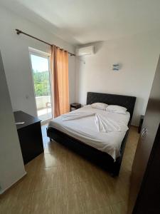 乌尔齐尼Lindi apartments的一间卧室设有一张床和一个大窗户
