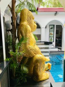 安吉利斯Golden Gorilla Villa with private pool & jacuzzi的坐在游泳池旁的熊雕像