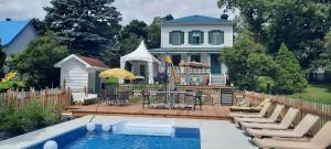 Saint-JeanLa maison de l'île的房屋设有带游泳池和椅子的庭院