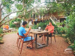 枚州县Mai Chau Valley Retreat的坐在花园里桌子上的两个人