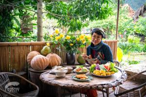 枚州县Mai Chau Valley Retreat的坐在餐桌上吃一盘食物的女人