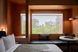 多伦多Ace Hotel Toronto的一间卧室设有窗户、一张床和一张沙发