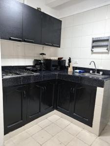 卡塔赫纳Centro las Bovedas A2-31 apartamento的厨房配有黑色橱柜和水槽