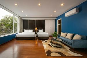 河内Hanoi 20 Hotel & Apartment的一间卧室设有两张床和蓝色的墙壁