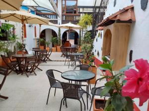 莱瓦镇Hotel Cemandy by MA的一个带桌椅和遮阳伞的户外庭院。