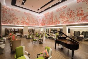 清莱The Heritage Chiang Rai Hotel and Convention - SHA Extra Plus的大堂设有三角钢琴和桌椅