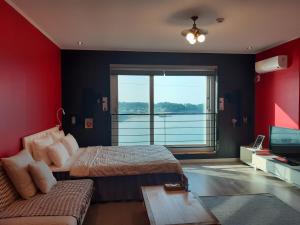 济州市Jeju Gaviota Pension的一间卧室配有两张床、一张沙发和一台电视