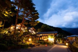 富士河口湖河口湖班乡间别墅酒店的一座以山为背景的夜间建筑