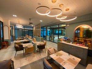 奥南海滩Infinity Aonang Krabi - SHA Certified的餐厅设有桌椅和窗户。