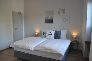 安德纳赫Boutique-Hotel "Stilvoll"的卧室配有一张带白色床单和枕头的大床。