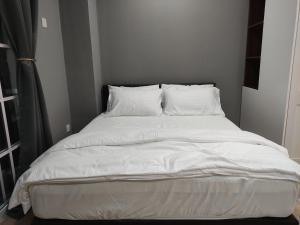 金宝Kampar Bonvoy Champs Elysees 4pax Homestay的一张配有白色床单和枕头的大床