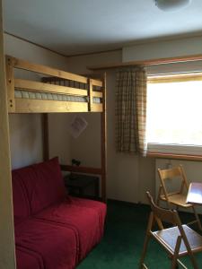 阿尔卑斯休斯山阿尔卑斯休斯山公寓的一间卧室配有双层床和红色沙发
