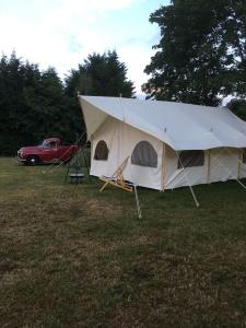 LincolnshireAmelia Vera的田野里的一个大型帐篷,有一辆红色卡车
